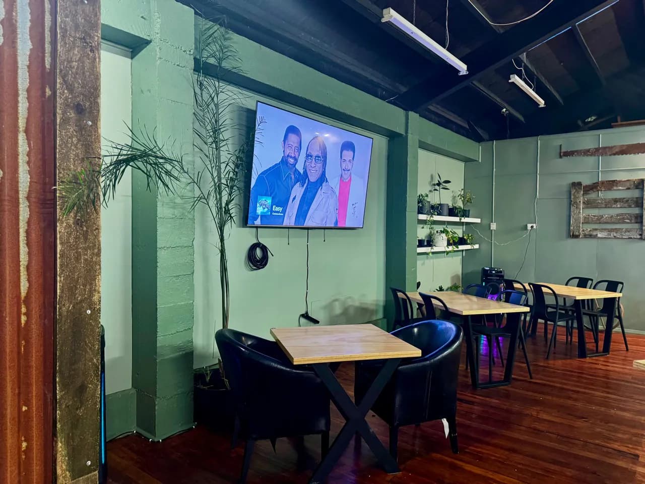 Lounge seating and dining tables beside the large television